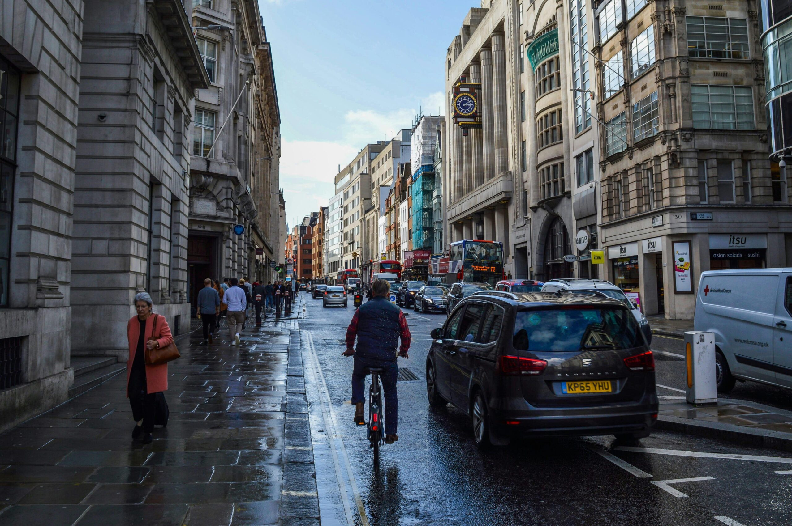 A road with pedestrians, buses and cyclists.